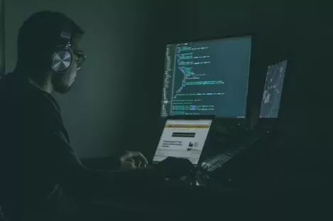 A man looking at code at a computer