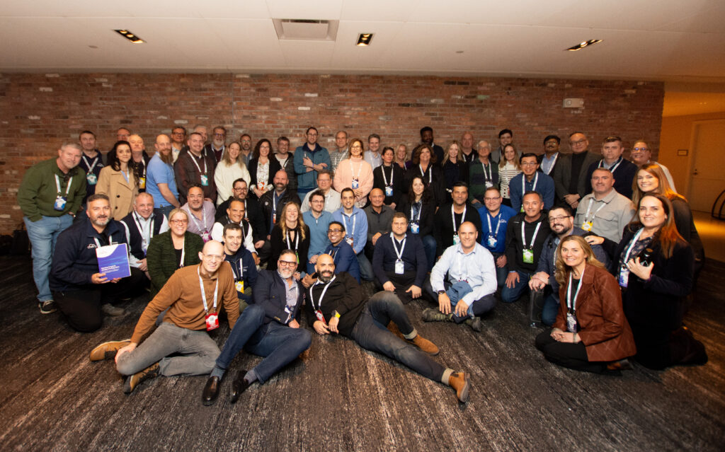 A large group photo of CTERA employees at their Sales Kick-Off (SKO) in Boston. The team is gathered in a conference room with a brick wall, smiling and posing for the camera.