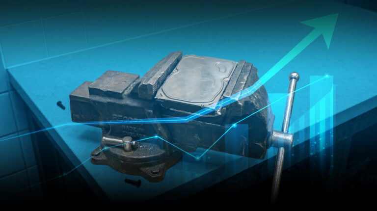 A hard drive clamped in a vise with a glowing blue chart and an upward-pointing arrow, representing data performance under pressure.